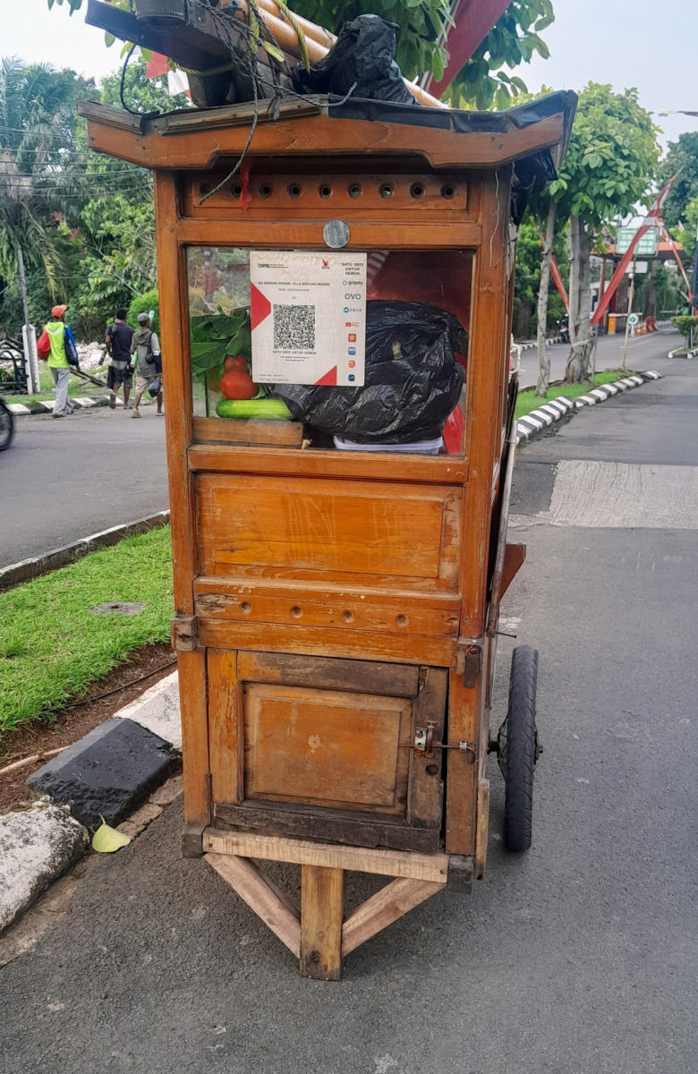 Gerobak jajanan dengan kode QRIS di jendelanya